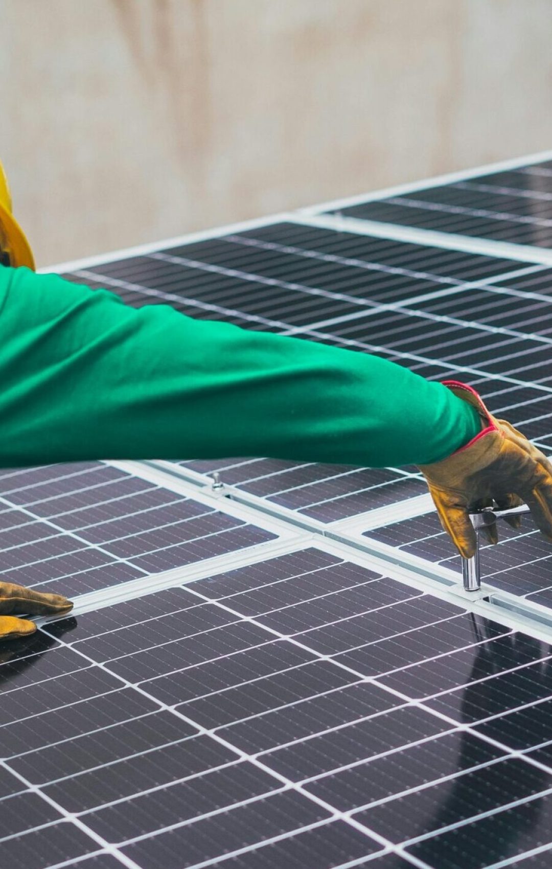 pexels-photo-8853502-8853502 Technician installing solar panels on a rooftop for sustainable energy solutions.